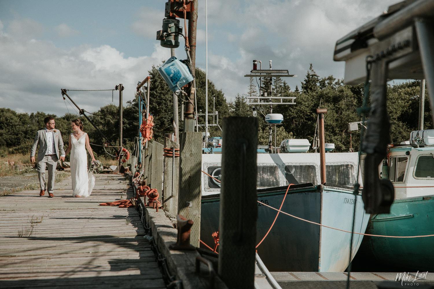 Bride and groom walking the pier at Moose Harbour in Nova Scotia.